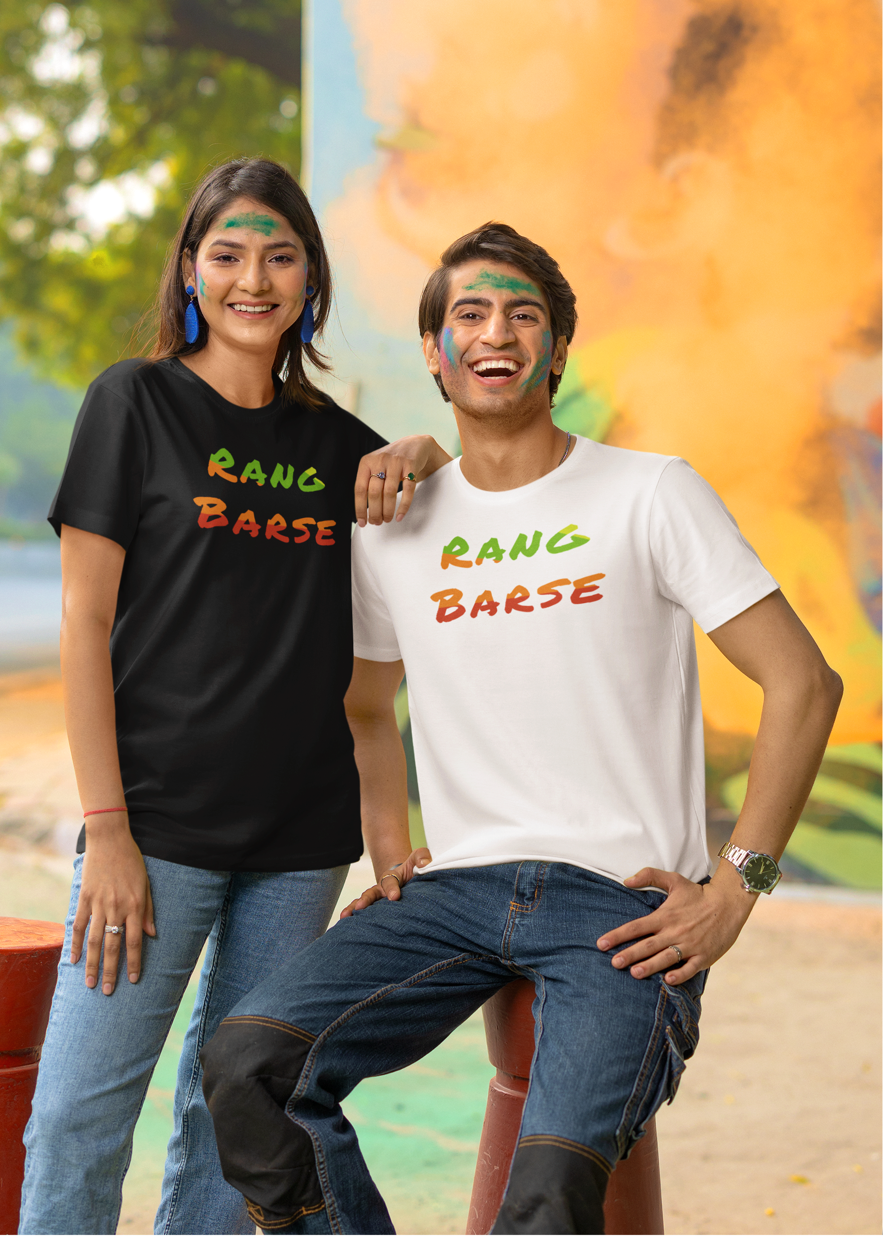 Two people wearing t-shirts with 'Rang Barse' text, standing outdoors with a colorful background.